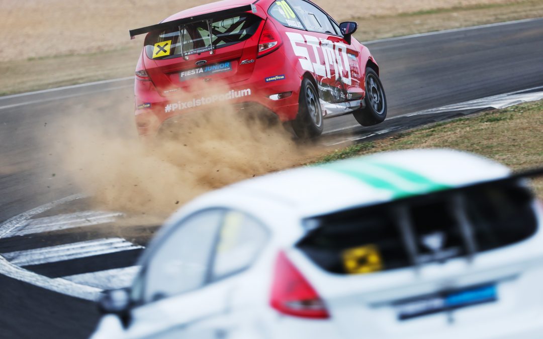 Benjy Douglas racing at Silverstone during Round 5 of the BRSCC Fiesta Junior Championship, overtaking competitors in his Fiesta Junior car.
